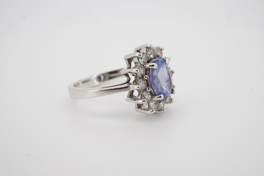 A modern 14k white metal, tanzanite and diamond set oval cluster ring, size M, gross weight 4.3 grams.